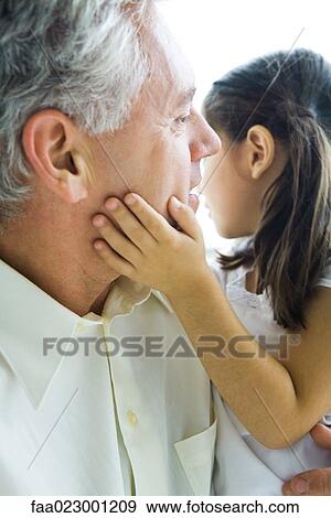 Stock Photo - Man holding little girl, girl's hand on man's cheek, close-up. Fotosearch