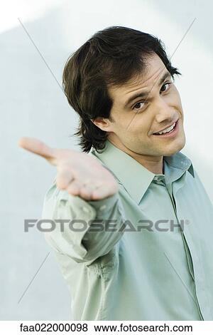 Man holding out hand to camera, portrait View Large Photo Image Stock Photo - Man holding out hand to camera, portrait. Fotosearch