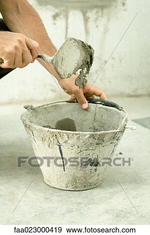 Man holding trowel over bucket, close-up of hands View Large Photo Image Stock Photo - Man holding trowel over bucket, close-up of hands. Fotosearch