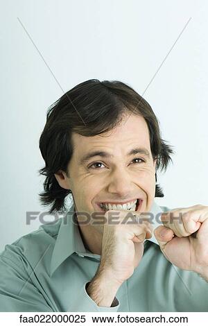 Man holding up fists and clenching teeth, portrait View Large Photo Image Stock Photography - Man holding up fists and clenching teeth, portrait. Fotosearch