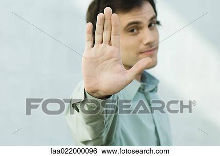 Man holding up palm to camera, portrait View Large Photo Image Stock Photograph - Man holding up palm to camera, portrait. Fotosearch