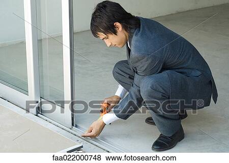Man in suit taking measurements next to sliding glass door View Large Photo Image Stock Photo - Man in suit taking measurements next to sliding glass door. Fotosearch