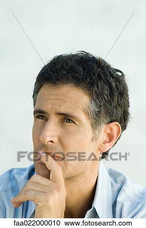 Man looking away, finger over lips, portrait View Large Photo Image Stock Image - Man looking away, finger over lips, portrait. Fotosearch