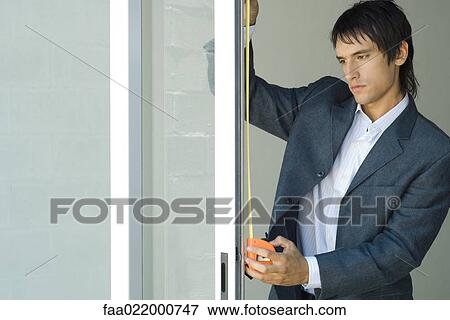 Man measuring sliding glass door View Large Photo Image Stock Photo - Man measuring sliding glass door. Fotosearch