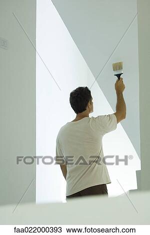 Man painting wall with paintbrush View Large Photo Image Stock Image - Man painting wall with paintbrush. Fotosearch