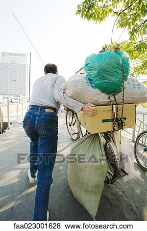 Man pushing bike laden with packages and bags, rear view View Large Photo Image Stock Photo - Man pushing bike laden with packages and bags, rear view. Fotosearch