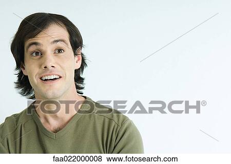 Stock Photo - Man raising eyebrows, smiling, portrait. Fotosearch