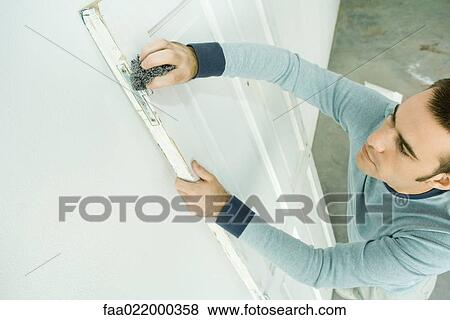 Man scouring hinge on door, high angle view View Large Photo Image Stock Photo - Man scouring hinge on door, high angle view. Fotosearch