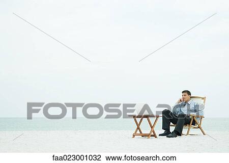 Man sitting in chair on the beach, looking at laptop computer, hand under chin View Large Photo Image Stock Image - Man sitting in chair on the beach, looking at laptop computer, hand under chin. Fotosearch