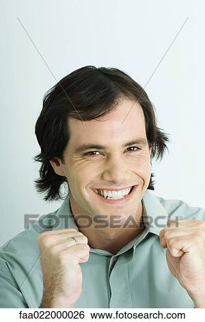 Man smiling, clenching fists, portrait View Large Photo Image Stock Photograph - Man smiling, clenching fists, portrait. Fotosearch