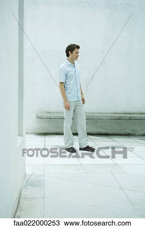 Man standing in courtyard, looking away, full length portrait View Large Photo Image Stock Image - Man standing in courtyard, looking away, full length portrait. Fotosearch
