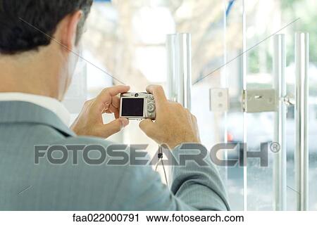 Man taking photo of lock on glass door, focus on digital camera View Large Photo Image Stock Image - Man taking photo of lock on glass door, focus on digital camera. Fotosearch