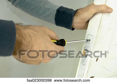 Man unscrewing look on door, close-up of hands View Large Photo Image Stock Photo - Man unscrewing look on door, close-up of hands. Fotosearch