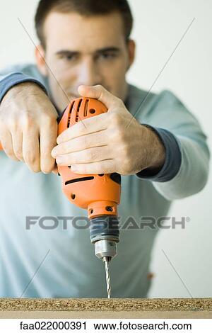 Man using drill, focus on drill in foreground View Large Photo Image Stock Image - Man using drill, focus on drill in foreground. Fotosearch
