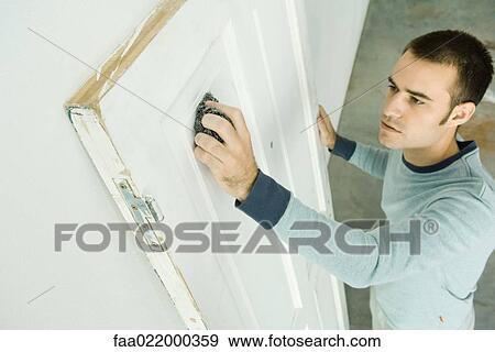 Man using scouring pad on door, high angle view View Large Photo Image Stock Photo - Man using scouring pad on door, high angle view. Fotosearch