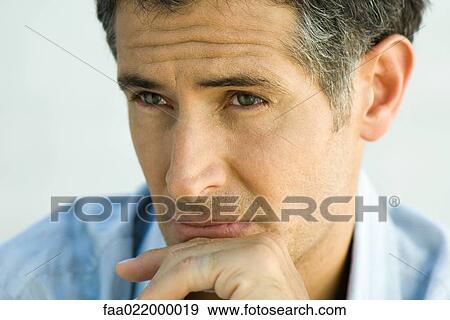 Stock Photo - Man with hand on chin, looking away, portrait. Fotosearch