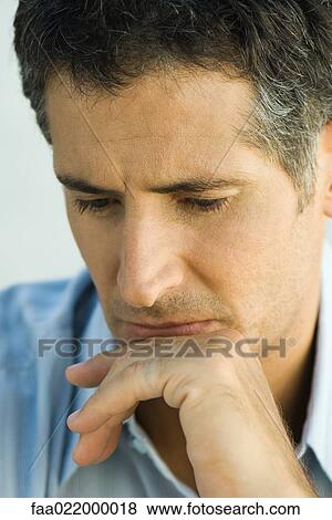 Man with hand on chin, looking down, portrait View Large Photo Image Stock Photo - Man with hand on chin, looking down, portrait. Fotosearch