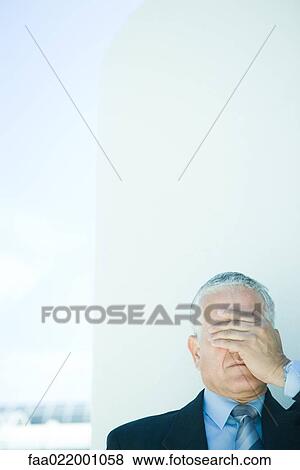 Stock Photo - Mature businessman, hand covering eyes, head and shoulders. Fotosearch