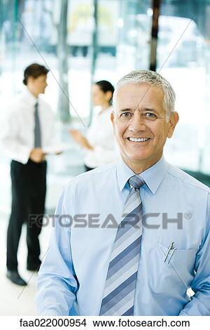 Mature businessman smiling at camera, waist up, portrait View Large Photo Image Picture - Mature businessman smiling at camera, waist up, portrait. Fotosearch