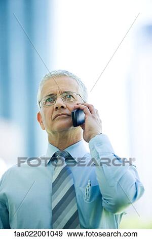 Mature businessman using cell phone, looking up View Large Photo Image Stock Photo - Mature businessman using cell phone, looking up. Fotosearch