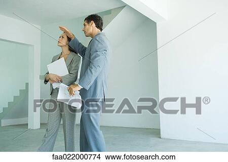 Mature male real estate agent showing home to female client View Large Photo Image Picture - Mature male real estate agent showing home to female client. Fotosearch