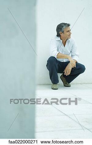 Mature man crouching, looking away, smiling, full length portrait View Large Photo Image Stock Image - Mature man crouching, looking away, smiling, full length portrait. Fotosearch