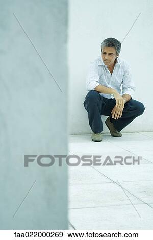 Mature man crouching, looking down, full length portrait View Large Photo Image Stock Photo - Mature man crouching, looking down, full length portrait. Fotosearch