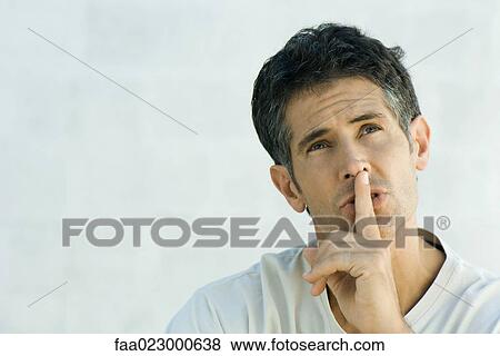 Mature man holding finger over lips, looking up, portrait View Large Photo Image Stock Photo - Mature man holding finger over lips, looking up, portrait. Fotosearch