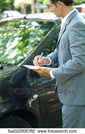 Mature man in suit inspecting car View Large Photo Image Stock Image - Mature man in suit inspecting car. Fotosearch
