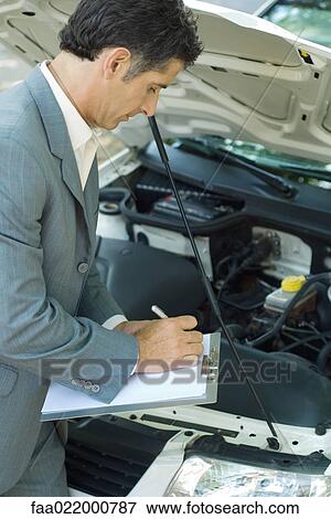 Mature man in suit inspecting car View Large Photo Image Stock Photo - Mature man in suit inspecting car. Fotosearch