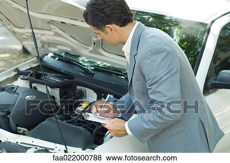 Mature man in suit inspecting car View Large Photo Image Stock Photo - Mature man in suit inspecting car. Fotosearch