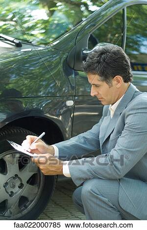 Mature man in suit inspecting car View Large Photo Image Stock Photography - Mature man in suit inspecting car. Fotosearch