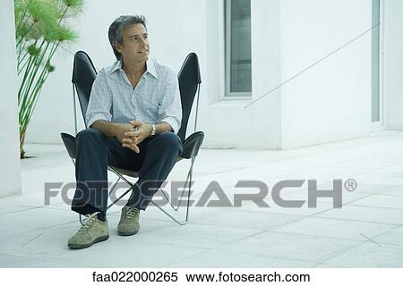 Mature man sitting in chair, smiling, full length View Large Photo Image Stock Photography - Mature man sitting in chair, smiling, full length. Fotosearch
