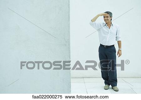 Mature man standing, shading eyes, smiling, full length portrait View Large Photo Image Stock Photography - Mature man standing, shading eyes, smiling, full length portrait. Fotosearch
