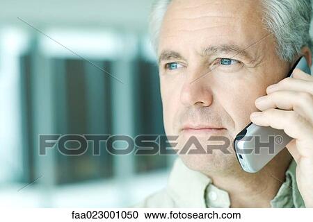 Mature man using cell phone, looking away, portrait View Large Photo Image Stock Image - Mature man using cell phone, looking away, portrait. Fotosearch