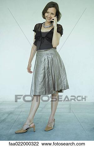 Mature woman standing, using cell phone, full length portrait View Large Photo Image Stock Image - Mature woman standing, using cell phone, full length portrait. Fotosearch