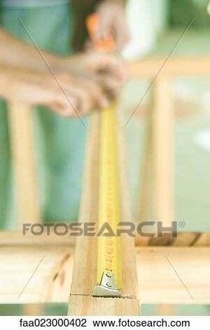 Measuring piece of wood, focus on measuring tape in foreground View Large Photo Image Stock Image - Measuring piece of wood, focus on measuring tape in foreground. Fotosearch