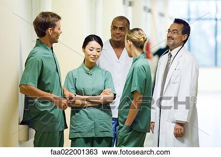 Medical staff chatting in hospital corridor View Large Photo Image Stock Image - Medical staff chatting in hospital corridor. Fotosearch