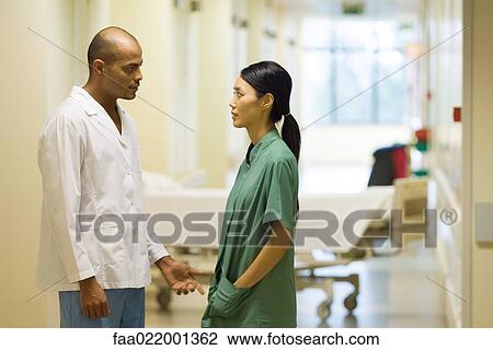 Medical staff standing face to face in hospital corridor, discussing View Large Photo Image Stock Image - Medical staff standing face to face in hospital corridor, discussing. Fotosearch