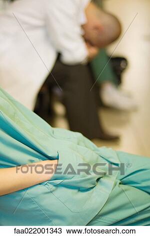 Medical worker with hands in pockets, doctor with head down in background, cropped view View Large Photo Image Stock Image - Medical worker with hands in pockets, doctor with head down in background, cropped view. Fotosearch