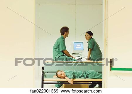 Medical workers chatting in office, one lying down on bench, eyes closed View Large Photo Image Stock Photo - Medical workers chatting in office, one lying down on bench, eyes closed. Fotosearch