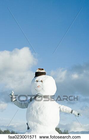 Stock Image - Person sticking arms out from behind snowman. Fotosearch