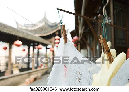 Stock Photograph - Plastic gloves and rag hanging to dry, Chinese lanterns hanging in background. Fotosearch