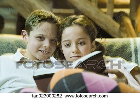Preteen boy and girl reading book together View Large Photo Image Stock Image - Preteen boy and girl reading book together. Fotosearch