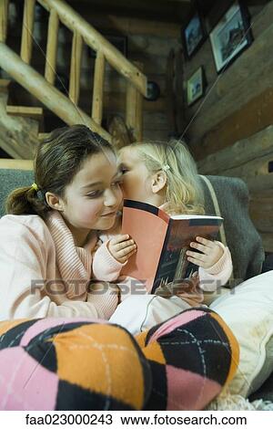 Preteen girl reading book with toddler, toddler whispering to her View Large Photo Image Stock Image - Preteen girl reading book with toddler, toddler whispering to her. Fotosearch