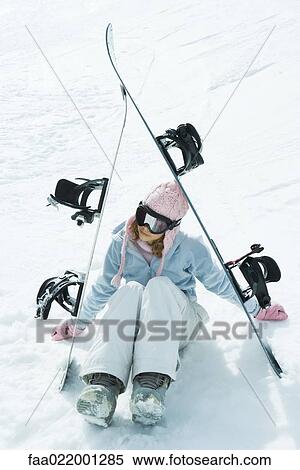 Preteen girl sitting on snow underneath propped up snowboards View Large Photo Image Stock Photography - Preteen girl sitting on snow underneath propped up snowboards. Fotosearch