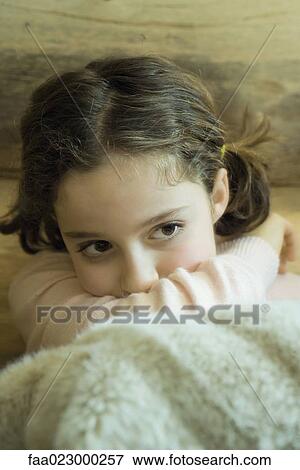 Preteen girl sitting under warm blanket, resting head on arm View Large Photo Image Stock Photo - Preteen girl sitting under warm blanket, resting head on arm. Fotosearch