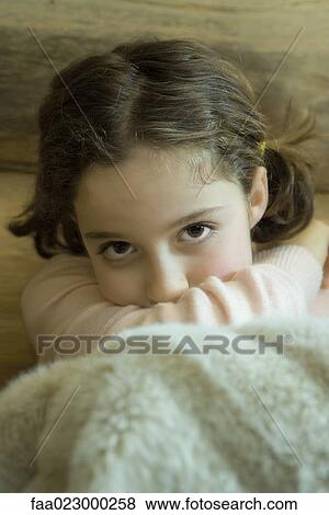 Preteen girl sitting under warm blanket, resting head on arm View Large Photo Image Stock Photo - Preteen girl sitting under warm blanket, resting head on arm. Fotosearch