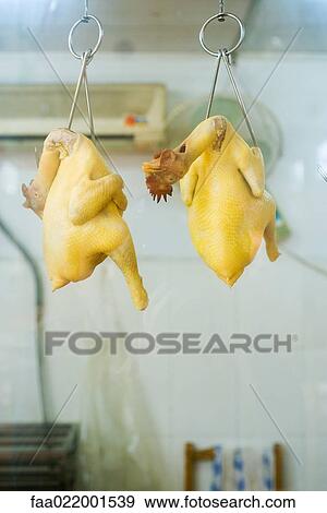 Stock Photo - Raw skinned chickens hanging from hooks. Fotosearch