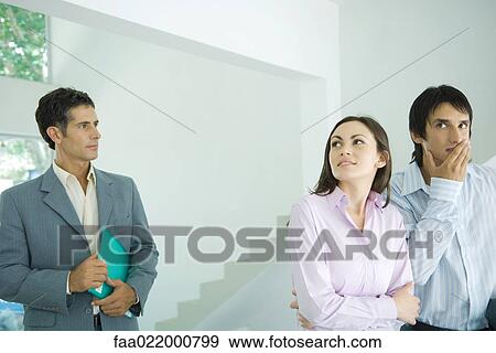 Real estate agent showing house to hesitant young couple View Large Photo Image Stock Photo - Real estate agent showing house to hesitant young couple. Fotosearch